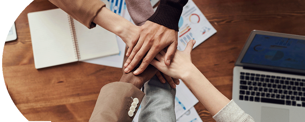 Eine Gruppe von Geschäftsleuten vereint ihre Hände in einem Zeichen der Zusammenarbeit und des Teamgeists.